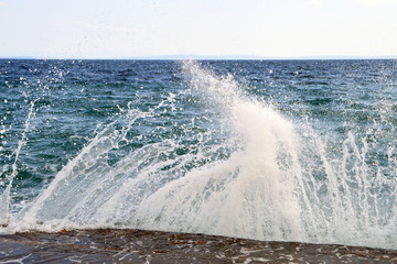 Breaking on stone pier splashing waves