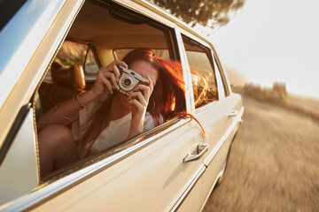 Female capturing a perfect road trip moment.