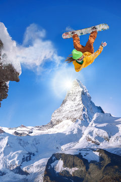 Snowboarder jumping against Matterhorn peak in Switzerland