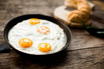 Fried egg in a frying pan on a wooden table