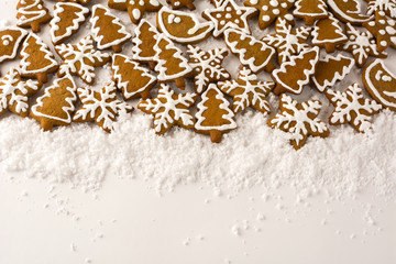 Christmas snowflake and fir tree gingerbread on a white snow background, copy space