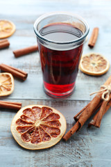 Tasty mulled wine and spices, on blue wooden background, close-up