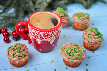 Red mug with coffee and Christmas cupcakes