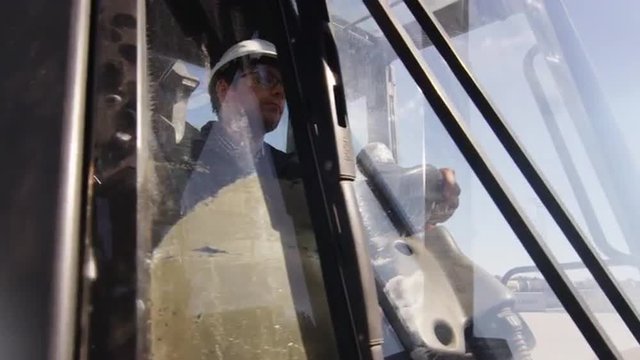 Loader Operator in Hard Hat in Cabin. Shot on RED Cinema Camera.