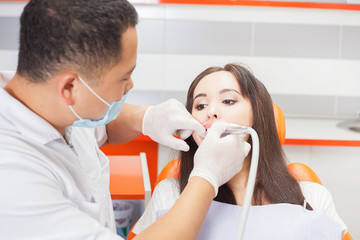 Dentist doctor treats teeth patient girl in dental office