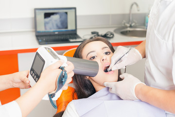 Dentist doctor doing dental treatment and using x-ray computer