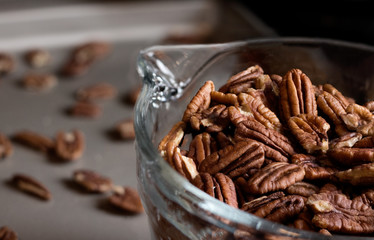 Closeup of uncooked pecans in a measuring cup