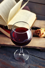 Beautiful composition with glass of wine with old books on table close up