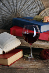 Beautiful composition with glass of wine with old books on table close up