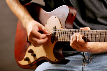Fototapeta premium Young musician playing electric guitar close up