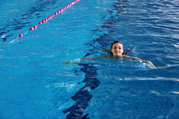 Beautiful young woman swimming in pool