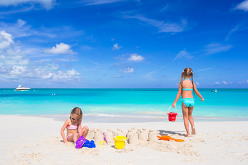 Fototapeta na wymiar Little girls playing with beach toys during tropical vacation