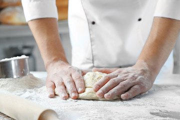 Making dough by male hands at bakery