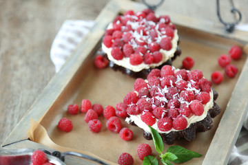 Sweet cakes with raspberries on wooden table background