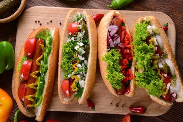 Hot dogs and vegetables on wooden cutting board