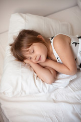 Obraz na płótnie Canvas girl in a bright dress sleeping on the bed