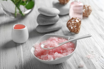 Composition of flowers, salt and stones on white wooden background, in spa salon