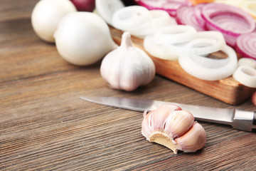 Composition of onions and garlic on wooden background