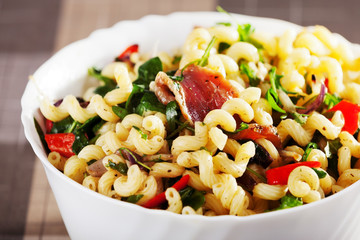 Pasta with prosciutto, rucola and peppers