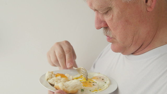 man eats eggs and biscuit breakfast 