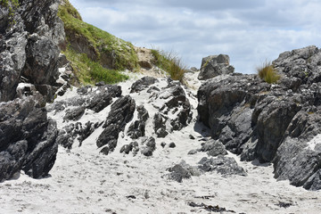 End of a beach with sand on the rocks found there.
