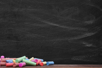 Multicoloured chalk on blackboard background © Africa Studio