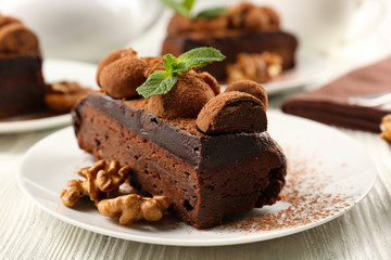 Piece of chocolate cake with walnut and mint on the table, close-up