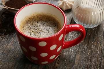 Cup of coffee with sweets on wooden background