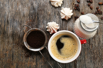 Cup of coffee with sweets on wooden background