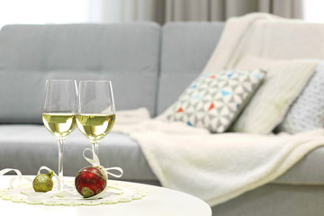 Two champagne glasses with Christmas decor on home interior background