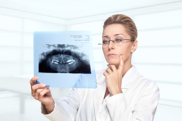 Female dentist examining  teeth x ray image