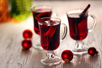 Mulled wine with red Christmas toys on wooden table