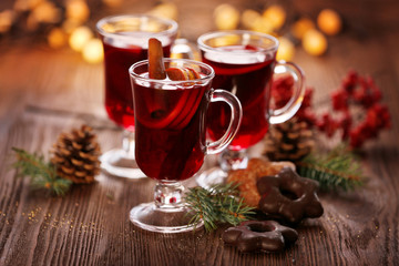 Mulled wine with cookies on wooden table