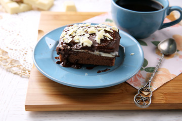 Delicious chocolate brownie on plate on wooden background