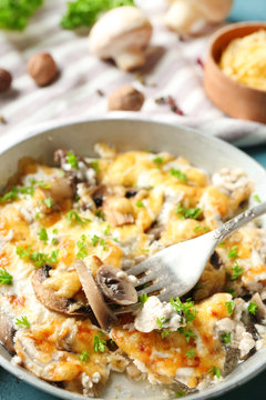 Roasted mushrooms, chicken and cheese gratin in pan, on color wooden background