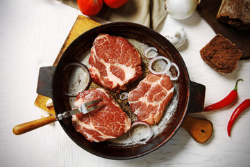 Marbled beef steak on pan and spices on color wooden background