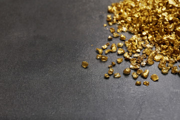Fototapeta na wymiar A pile of Gold nugget grains, on cement background