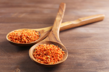 Two wooden spoons with spice on the table, close-up