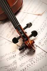 Naklejka premium Violin neck on music papers background