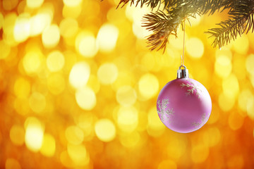 Christmas bauble on a fir branch and glitter background