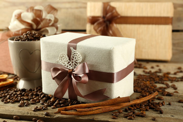 Beautiful gifts with bows and coffee grains on wooden background