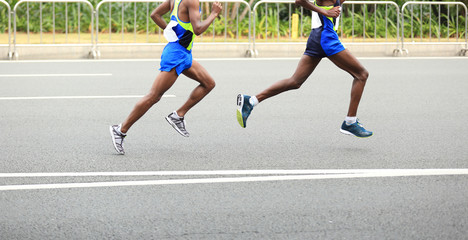 Fototapeta premium Marathon runner running on city road