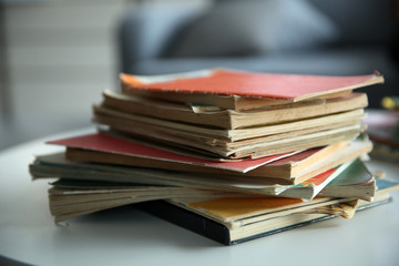 Pile of old books on white table. Focus on books and blurred background