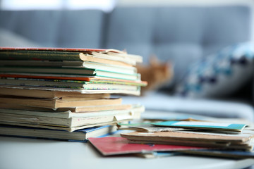 Pile of old books on white table in the room. Focus on books and blurred background