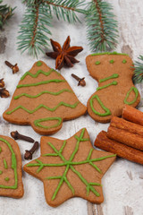 Decorated gingerbread, spruce branches, spices on old wooden background, christmas decoration