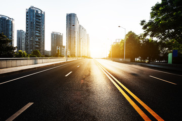 Fototapeta premium sunlight,empty asphalt road by modern buildings