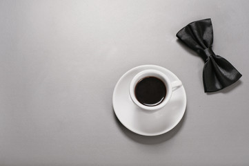 Cup of black coffee with a man bow tie