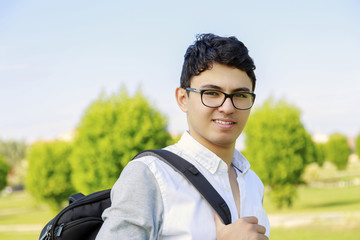 Student with backpack outside school.