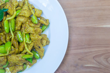 fry pork with curry paste on wood table