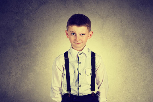 Funny emotionof  little boy young man with a raised eyebrow wearing costume with braces.Happy little boy over white background.Smiling, Happy, Joyful beautiful little boy , looking at camera.